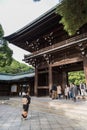 People walk through Wooden shrine Meiji Shinto in Shibuya Japan