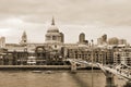 People walking across a footbridge Millennium Bridge. Background is St Paul`s cathedral Royalty Free Stock Photo