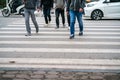 People walking across a street while cars keep running on street in Hanoi, Vietnam. Closeup