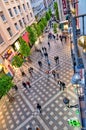 People walking along Madrid pedestrian old town street high angle view.