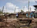 People walking along an open sewer in a slum in Africa Royalty Free Stock Photo