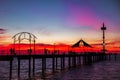 People walking along pier at sunset Royalty Free Stock Photo