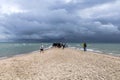 People walking along the seashore at cape Grene, Skagen Odde, Denmark. Overcast sky.