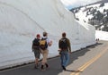 People are walking along the snow drift in the middle of summer