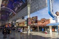 People walking along the street at the Fremont Street Experience with restaurants and retail stores and a video screen ceiling