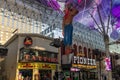 People walking along the street at the Fremont Street Experience with restaurants and retail stores and a video screen ceiling