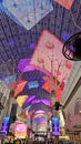 People walking along the street at the Fremont Street Experience with restaurants and retail stores and a video screen ceiling