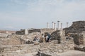 People walking amongst and take pictures of the ruins on island of Delos, Greece