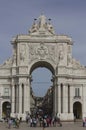 People walking around and the triumphal arch in Lisbon