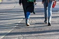 People walking on asphalt sidewalk on sunny day, legs and shadows Royalty Free Stock Photo