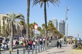 People walking on Barceloneta in front of the Mediterranean sea.