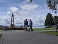 People walking by the beach at the Kirkland Marina at Lake Washington, ducks and a large gazebo in the background