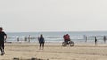 People walking on beach. Surfer men with surfboard going surfing. Family riding bike, California USA Royalty Free Stock Photo