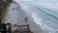 People walking on beach after surfing. Surfers near waves with surfboard. Encinitas, California USA