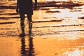 A People walking on the beach and water splash in sunset time