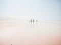 People walking on foggy beach. Cadiz, Spain Royalty Free Stock Photo