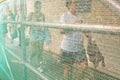 People walking behind a trellis fence