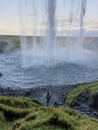 People walking behind waterfall Royalty Free Stock Photo