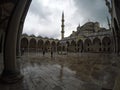 People walking at Blue Mosque courtyard, minaret in the background