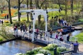 People walking on bridge over water canal in beautiful Keukenhof Garden, Holland