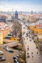 People are walking on Charles bridge, whose rooftops are covered by snow, Prague in the winter