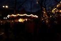 People walking at Christmas fair, blurred view. Street decorated with festive lights Royalty Free Stock Photo