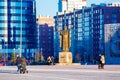 People walking in city near monument on spring day