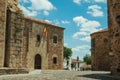 People walking in a cobblestone alley amidst gothic buildings at Caceres