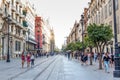 People walking during the day in a pedestrian street near Cathedral in Seville, Spain. Famous landmark. Royalty Free Stock Photo