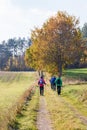 People walking on a dirt road in a beautiful autumn landscape