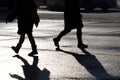 Black silhouettes and shadow of people walking down on a city street Royalty Free Stock Photo