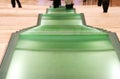 People walking down green glass steps of a wide stairway