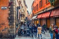 People are walking down typical italian street with buildings with bright colorful walls in old historical city centre