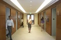 People walking in elevator lobby woman standing in middle Royalty Free Stock Photo