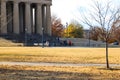 People walking enjoying a gorgeous autumn landscape in the park surrounded by yellow winter grass, autumn colored trees