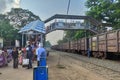 People walking through foot over bridge at Jhargram Railway station, West Bengal, India. Wide view of train