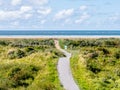 People walking on footpath to North Sea beach of Schiermonnikoog, Netherlands Royalty Free Stock Photo