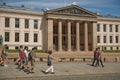 People walking in front of University of Oslo in Norway. Central campus, Faculty of Law building on Karl Johans Gate street