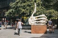 People walking by `Like ` sculpture by Krystof Hosek in Prague, Czech Republic.