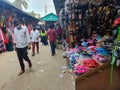 People walking in a local shoe market with street shops in Bangladesh during the corona with masks on their face