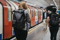 People walking on a London Underground station platform, moving train on the background, motion blur Royalty Free Stock Photo