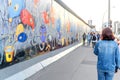 People walking and looking at Art gallery of Graffiti on Berlin Wall at East side