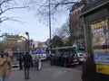 People walking, metro station entrance, cars, trees and posters on the wall in the city of Paris Royalty Free Stock Photo