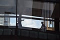 Sillouette of two people walking in a downtown skywalk.