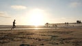 People walking, ocean beach. Silhouette of man running. Young guy training near pier California USA Royalty Free Stock Photo