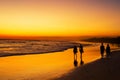 People walking ocean beach sunset Royalty Free Stock Photo