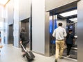 People are walking in office past elevators, Modern steel elevator cabins in a business lobby or