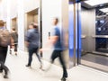 People are walking in office past elevators, Modern steel elevator cabins in a business lobby or