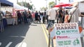 People walking on outdoor street farmers market. Vendors sell locally produced goods, California USA