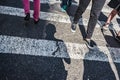 People walking over a cross walk on Fifth Avenue in New York City.